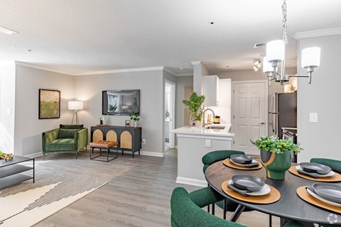 a living room and kitchen with a table and chairs